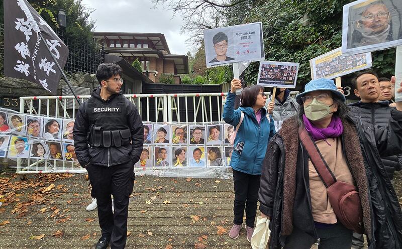 民众在中国驻温哥华领事馆前拉起了四十七人头像的横幅,为他们的无罪发出呐喊。中国领事馆特派出保全维安,保全人员并一直在现场拍照搜证。 (记者柳飞拍摄)