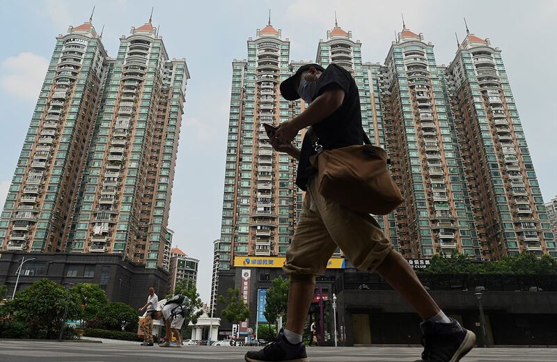 一名男子走过广州市恒大的住宅区。 (法新社)